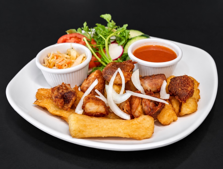 Fried yuca and pork chunks with onion, slaw and salsa