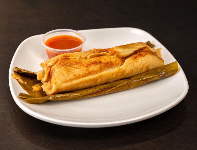 Tamal in banana leaf with salsa